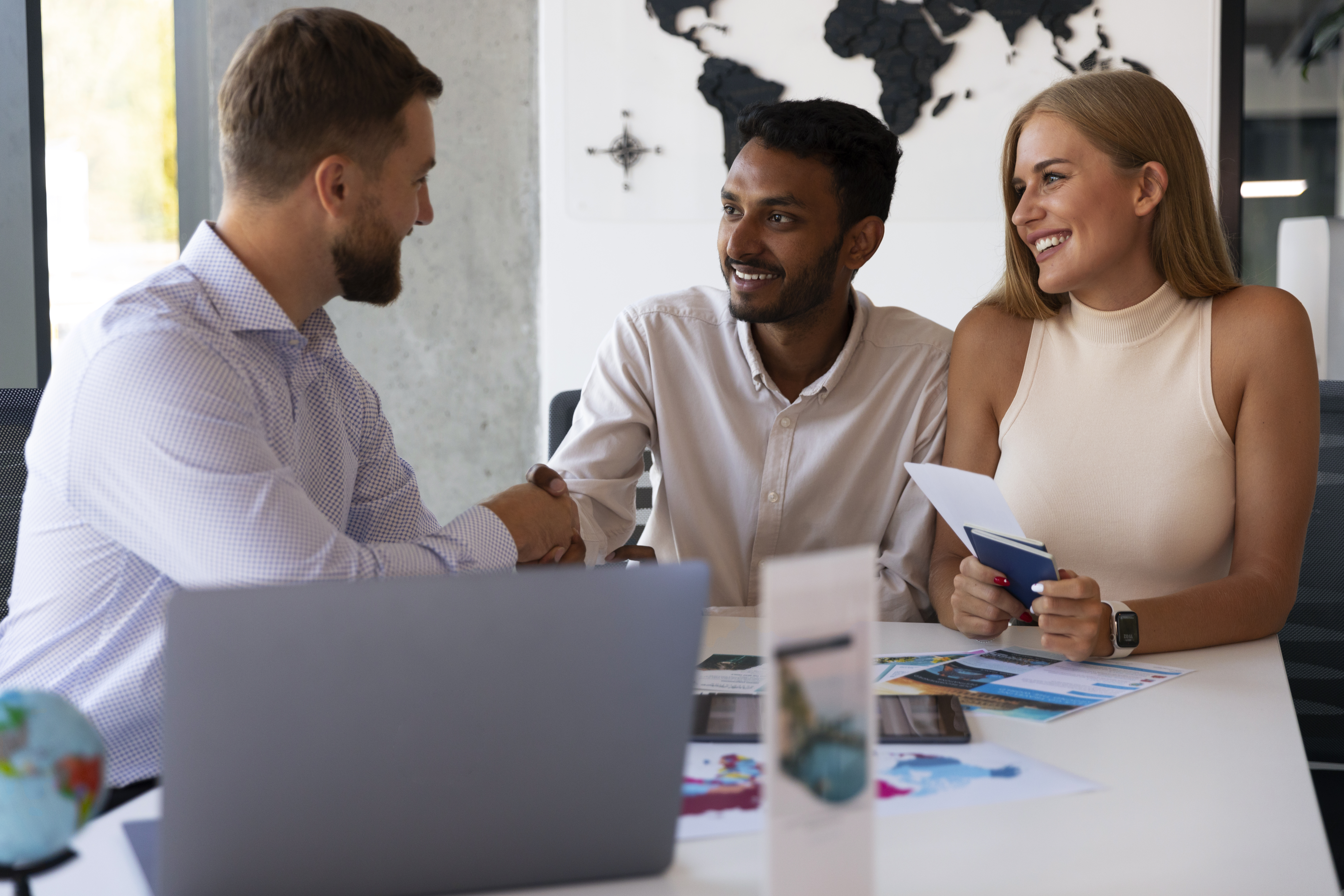 Three people collaborating on a laptop